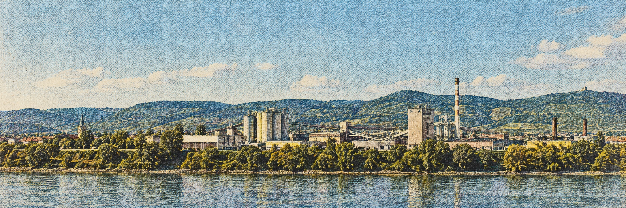 Illustrative Industrieanlage an einem Fluss mit grünen Hügeln.